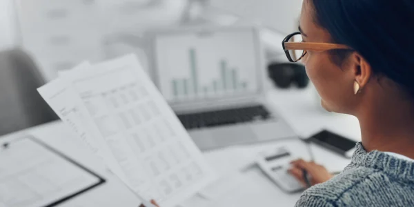 Persoon die financiële documenten analyseert.